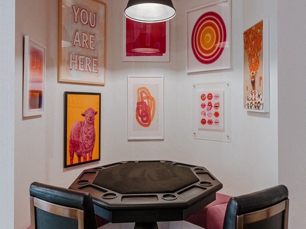 a poker table in a room with pictures on the wall